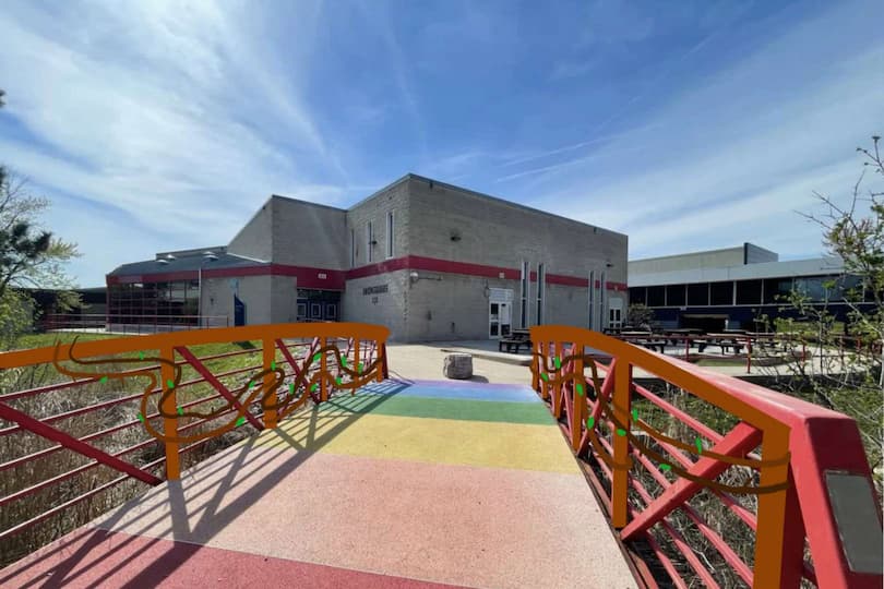 The wooden railing uses softer, more neutral colours that don't compete with the rainbow walkway, so the bridge still feels visually balanced. The small plant elements add a bit of life to the space while keeping the design simple and natural.